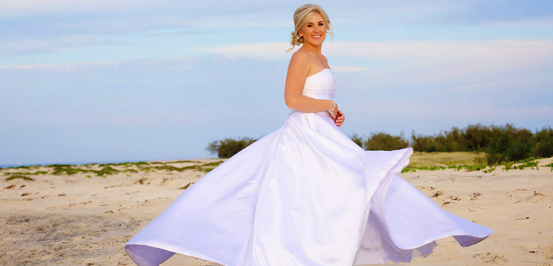 beautiful bride on beach with long white wedding dress at sunset in Caloundra, Queensland, Australia